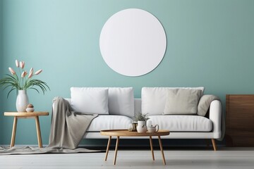 Rustic round table near white sofa against turquoise wall with empty blank mock up frame, Scandinavian home interior