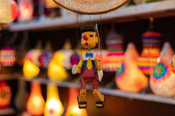 Wooden pinocchio style dolls for sale in outdoor market.
