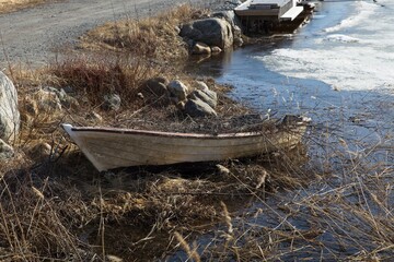 A weathered old abandoned boat on the coast in spring.
