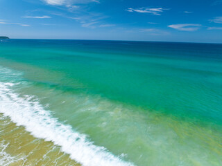 Aerial view of Waves crashing on sandy shore in sunny day,Sea surface ocean waves background,Top view beach background,Phuket Thailand