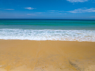 Aerial view of Waves crashing on sandy shore in sunny day,Sea surface ocean waves background,Top view beach background,Phuket Thailand