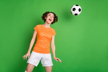 Photo of carefree astonished girl open mouth look flying ball head make shot isolated on green color background