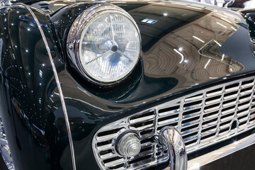 Headlight of an old classic car on display at a car show