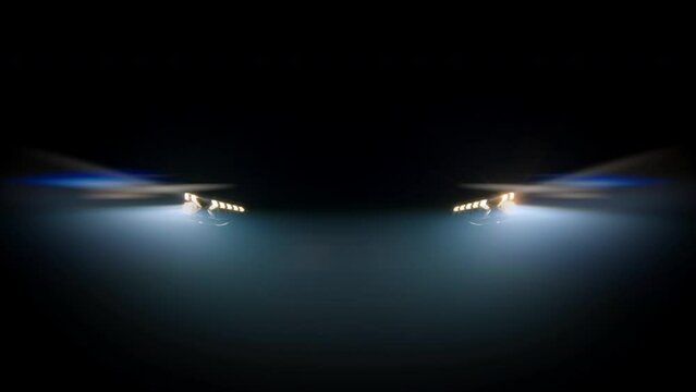 Close-up of an anonymous car's blinking headlights against a dark background in foggy lighting. Auto advertising concept, speed and lights.