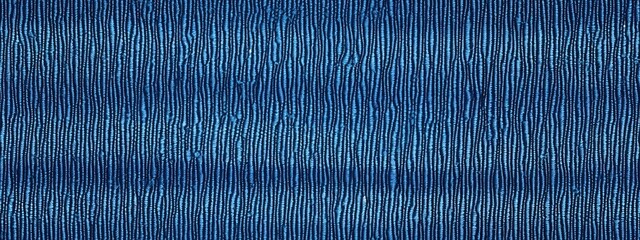 Seamless faded denim blue jeans texture background. Closeup detail of worn and distressed indigo tie dye pattern effect on rough linen or canvas. A fabric textile backdrop