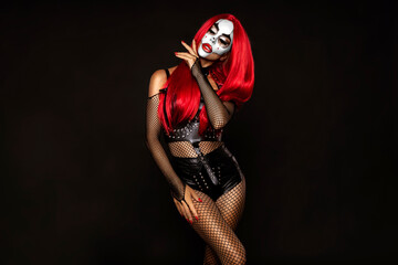 Sexy woman in a Halloween makeup and latex costume on black background. Halloween makeup and...