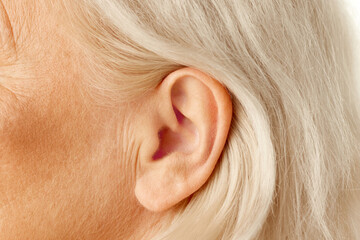 Close-up of female ear. Senior model. Hearing problems and health care, deafness, health check up....