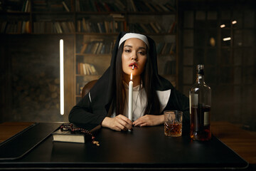 Immoral christian nun lighting cigarette from burning candle