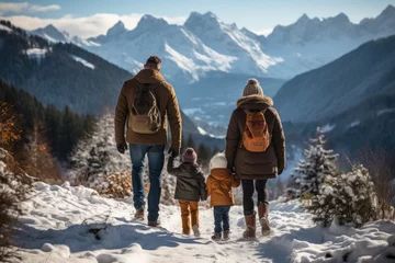 Tuinposter Rear view of a family with two small children on a walk overlooking the snowy mountains © Elen Nika