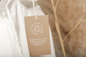 Close up of clothing tag with recycle icon. Recycling products concept. Zero waste, suistainale production, environment care and reuse concept.	 - obrazy, fototapety, plakaty