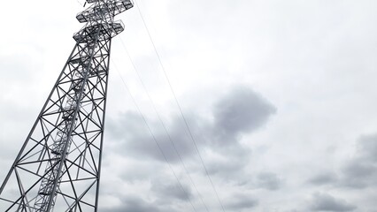 Lookikng up at Electric power tower with dramatic sky in background