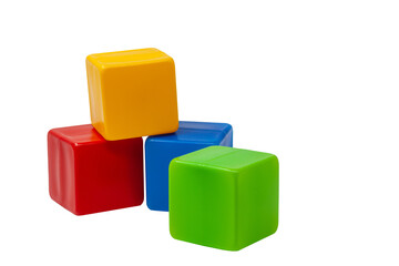 Multicolored plastic cubes for children's games. Yellow cube stands on top of red and blue cube, green cube stands next to it. PNG. One on one. High quality photo.