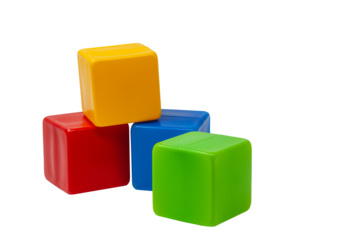 Multicolored plastic cubes for children's games. Yellow cube stands on top of red and blue cube, green cube stands next to it. PNG. One on one. High quality photo.