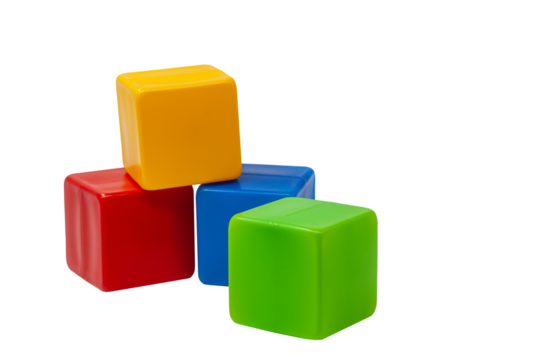 Multicolored plastic cubes for children's games. Yellow cube stands on top of red and blue cube, green cube stands next to it. PNG. One on one. High quality photo.