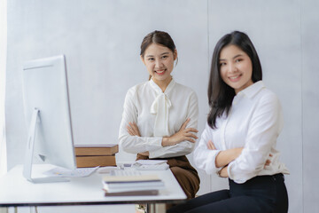 Two Asian businesswomen discuss investment project work and planning strategies on data charts and planning strategies. About new businesses in the online financial world Asian startup business ideas