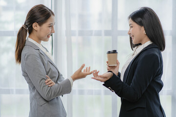 Two Asian businesswomen discuss investment project work and planning strategies on data charts and planning strategies. About new businesses in the online financial world Asian startup business ideas
