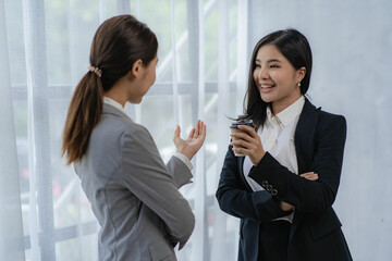 Two Asian businesswomen discuss investment project work and planning strategies on data charts and planning strategies. About new businesses in the online financial world Asian startup business ideas