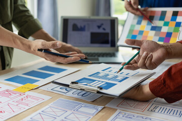 A team of web designers with the ux ui system are writing programs and layers to customize the...