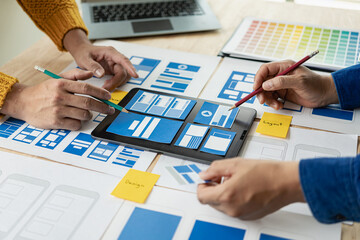 A team of web designers with the ux ui system are writing programs and layers to customize the appearance of the ux ui system and are working together to develop a mobile responsive website.