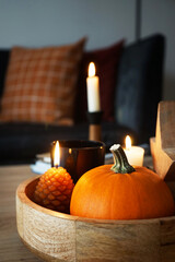 Burning candles and different autumn decor in a modern interior