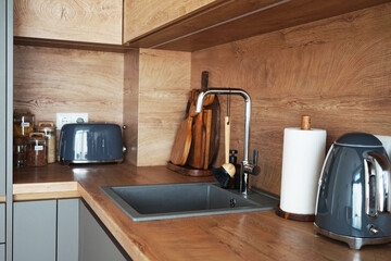Kitchen utensils, kettle, toaster on wooden modern kitchen
