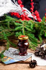 Jam from young pine cones in syrup on a background with pine branches