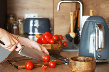 Fototapeta na wymiar Slicing fresh vegetables in a modern wooden kitchen