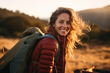 Portrait of girl looking at camera while near camping tent at sunset