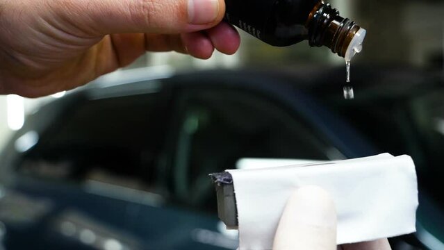 Staff wear Chemical protective clothing at work. Automobile industry. Car wash and coating business with ceramic coating.Spraying the varnish to the car. Concept of: Car protective, Service, Shine.	