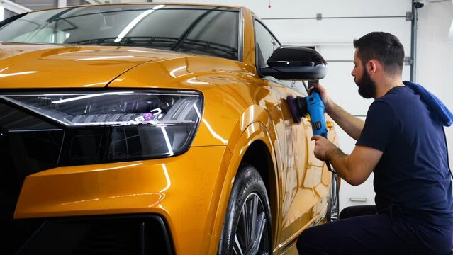 Staff wear Chemical protective clothing at work. Automobile industry. Car wash and coating business with ceramic coating.Spraying the varnish to the car. Concept of: Car protective, Service, Shine.	