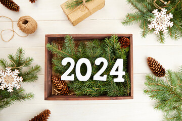 Numbers 2024 in a wooden gift box with spruce branches, eco-friendly organic decor. Happy New Year...