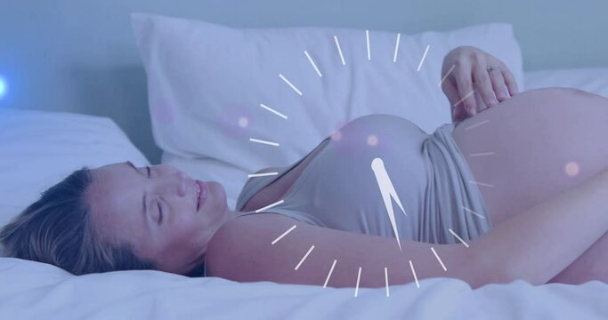 Fast moving clock over happy pregnant caucasian woman lying on bed rubbing belly