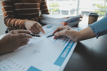 Financial analysts analyze business financial reports on a digital tablet planning investment...