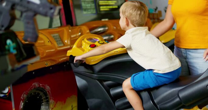 Kid playing arcade simulator machine at an amusement park