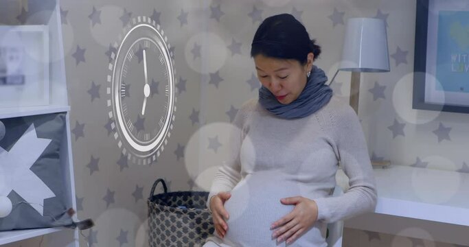 Fast moving clock and bokeh lights over happy a pregnant asian woman rubbing belly