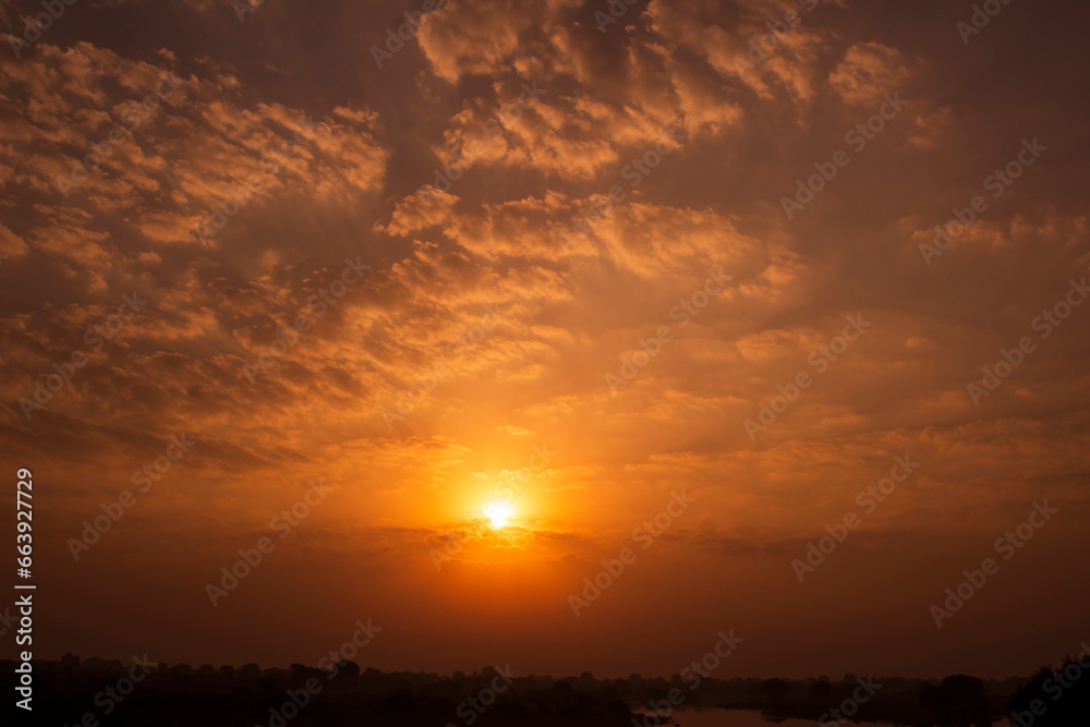 Wall mural sunset sky background with clouds and sunbeams. natural background.