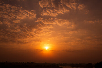 Sunset sky background with clouds and sunbeams. Natural background.