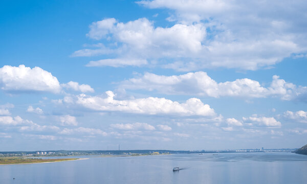 wide blue river and sky with clouds