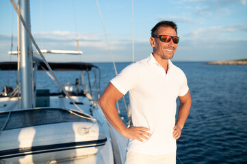 Confident handosme man in sunglasses on a yacht