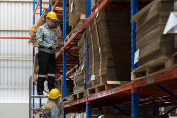 Male and female warehouse worker working and discussing in warehouse storage. Warehouse workers inspecting quality of barcodes on shelves pallet