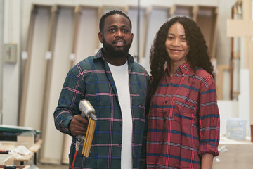 Portrait of African American male and female carpenter working at wood factory with happy smiling....