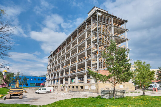 steel construction with stairs in front of office building with trees and grass