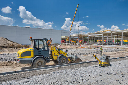 bulldozer and other construction equipment in front of construction site building modern gallery mall