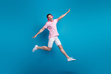 Full body portrait of active crazy person jumping hands wings listen favorite song isolated on blue color background