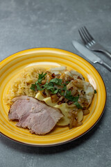 pork meat with potato dumplings and pickled cabbage served with roasted onion