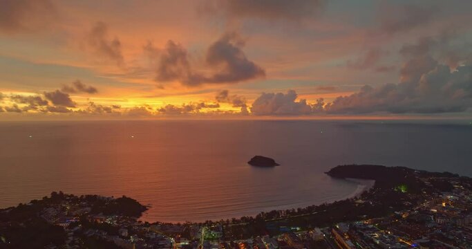 .Aerial view amazing yellow Light through the sky above Kata beach..Beautiful sunset are accompanied by soft clouds floating in stunning sky..wonderful sunset soft clouds floating above the sea.
