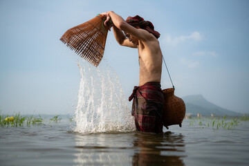 Fisherman using traditional fishing gear to catch fish for cooking, Rural Thailand living life...