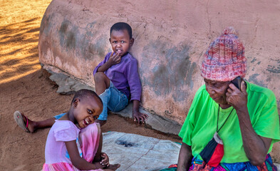 village old senior woman talking on the phone, and chatting with her grandchildren