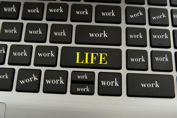 The words life and work are written on the keys of the laptop keyboard.