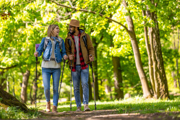 Obraz premium Young couple with scandinavian sticks walking and talking